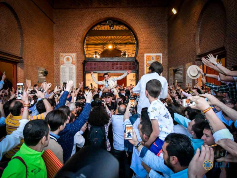 Celebración en una iglesia con fieles levantando a un hombre en el centro, rodeado por una multitud entusiasta.