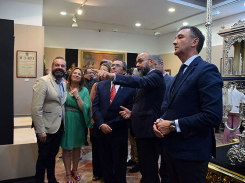 Una reunión de negocios en un salón elegante, con personas intercambiando ideas y sonriendo. La atmósfera es formal y amistosa, con un ambiente de trabajo colaborativo.