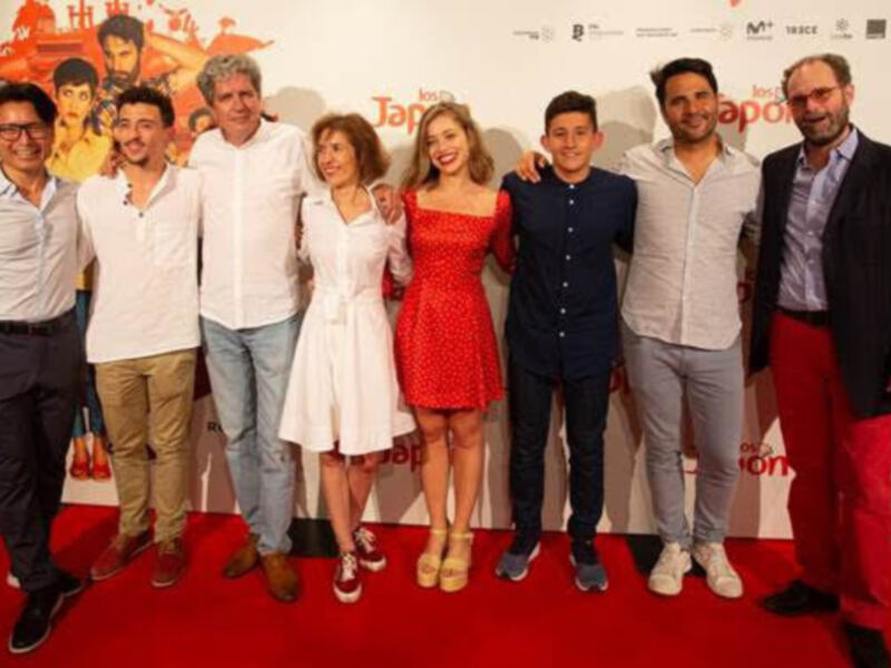 Equipo de cine en la alfombra roja, con actores y directores posando para la foto.