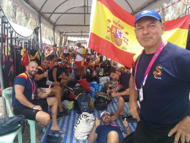 Equipo español de atletismo posando con la bandera nacional en un evento deportivo.