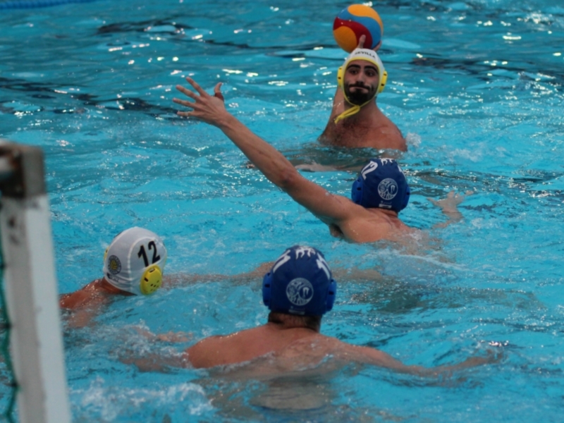 Jugadores de waterpolo en acción durante un partido en piscina.