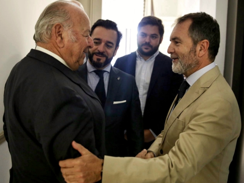 Dos hombres se saludan con un apretón de manos en un encuentro formal.