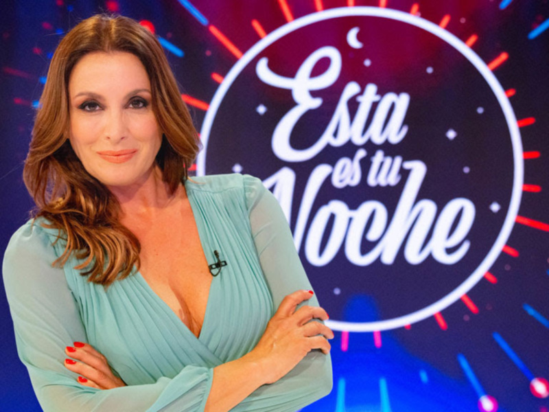 Presentadora en un estudio con fondo vibrante y el texto 'Esta es tu noche'