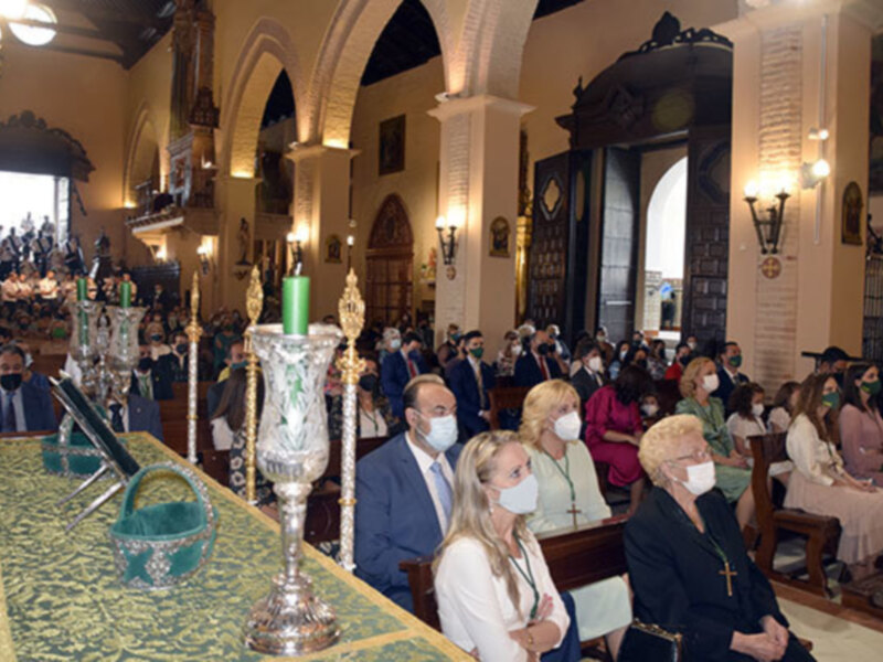 Celebración religiosa en una iglesia con fieles asistentes usando mascarillas.