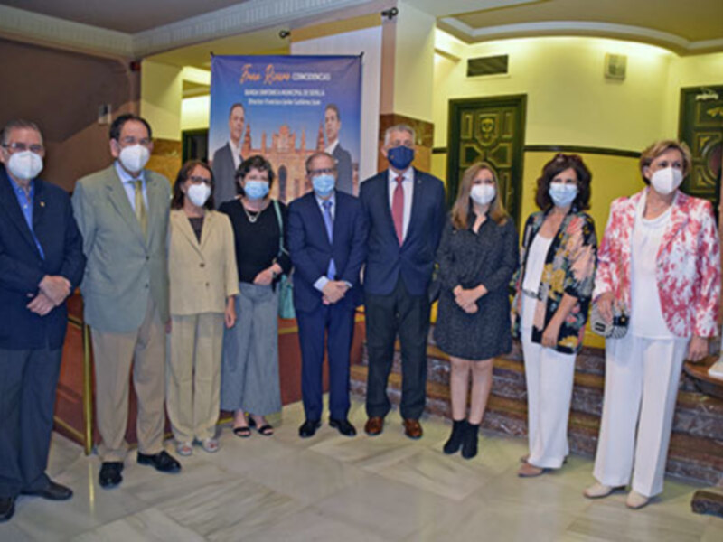 Conferencia de prensa con participantes en trajes formales y mascarillas, junto a un cartel con el logotipo de 'Foro Río Conocidos'.