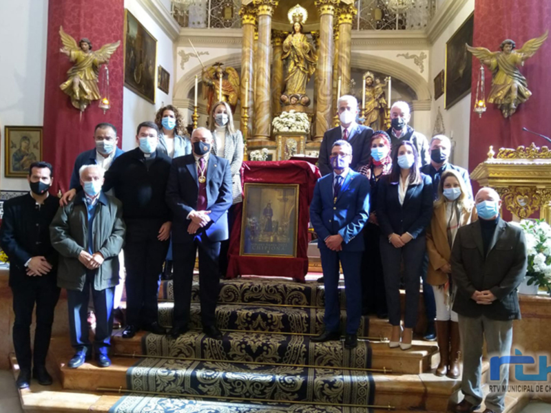Grup de persones amb mascaretes davant d'un altar religiós durant una cerimònia oficial.