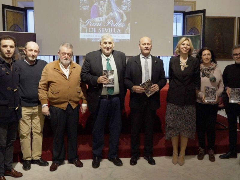 Presentación del libro "Gran Poder de Sevilla" en un evento con autoridades y participantes.