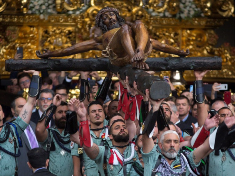 Una imagen de una multitud en una iglesia, con un hombre en la cruz al centro. La gente está tomando fotos y parece estar emocionada.
