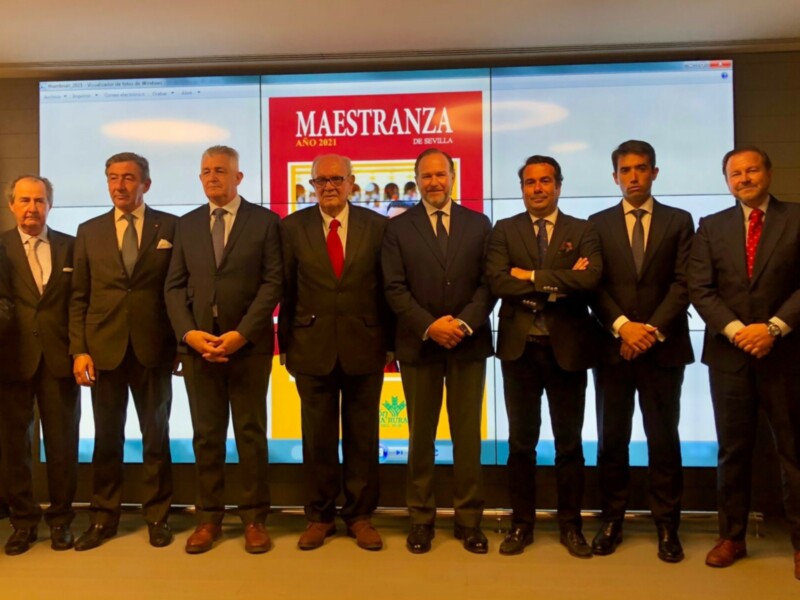 Grupo de empresarios posando frente a un fondo con el logo de Maestranza de Sevilla en el año 2021.