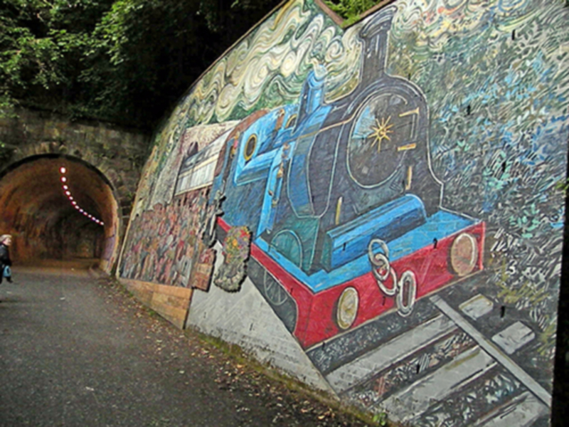 Mural de tren en un túnel, arte callejero vibrante y detallado.