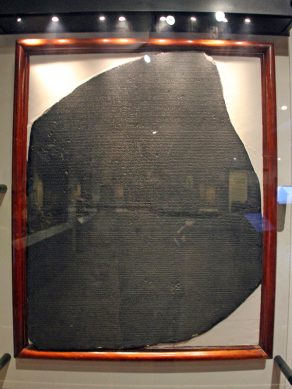 Tablilla de cera antigua enmarcada, expuesta en un museo.
