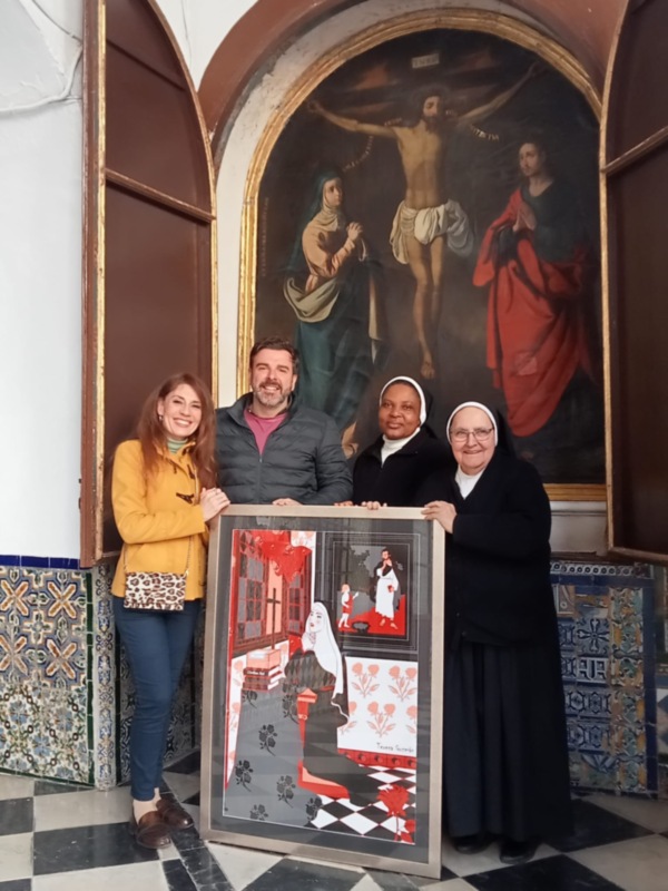 Se observa a tres personas, dos adultos y una mujer mayor vestida con un hábito religioso. El adulto en el centro sostiene una pintura que representa a un personaje vestido con trajes de época. A la izquierda, una mujer joven con cabello largo y una chaqueta amarilla sostiene la pintura. La mujer mayor, a la derecha, también sostiene la pintura y está vestida con un hábito religioso. En el fondo, se puede ver una pintura de la crucifixión y azulejos con diseños geométricos.