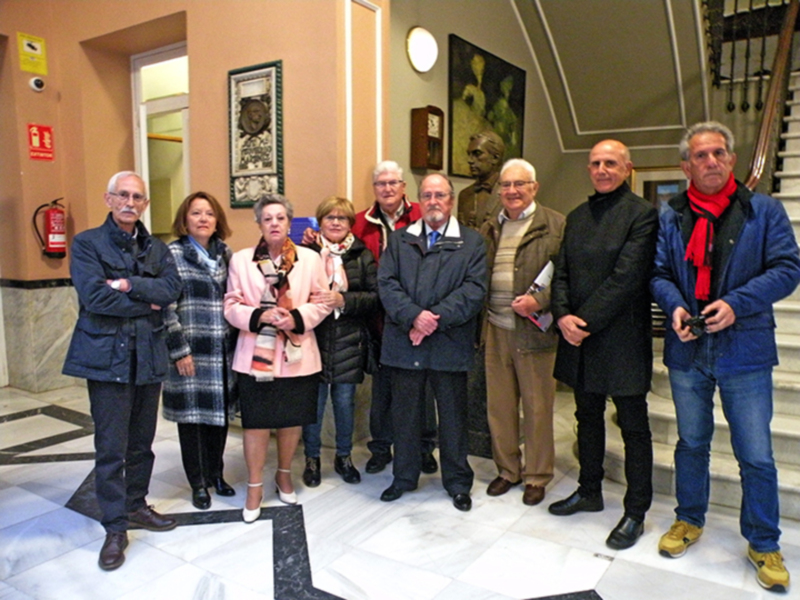Gruppo di anziani in posa per una foto all'interno di un edificio storico.