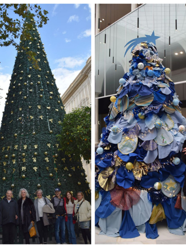 Árbol de Navidad tradicional y moderno, uno decorado con bolas doradas y el otro con telas y luces, junto a un grupo de personas.
