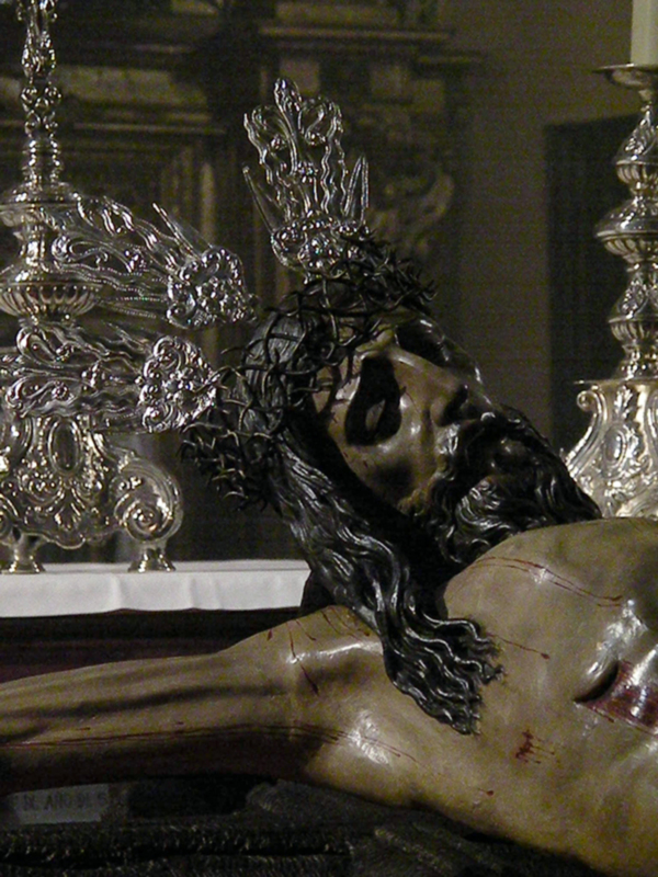 Cristo de la Buena Muerte, imagen religiosa con detalles en plata y rostro con sangre representando la Pasión de Cristo.