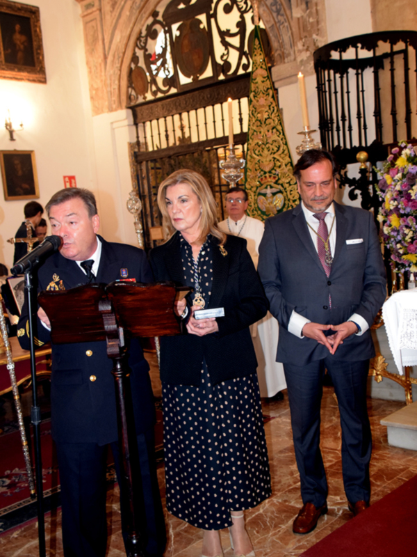 Celebración oficial en una iglesia histórica con personas en trajes formales y un micrófono en primer plano.
