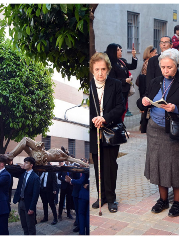 Procesión religiosa con personas rezando y portando un crucifijo en una calle urbana.