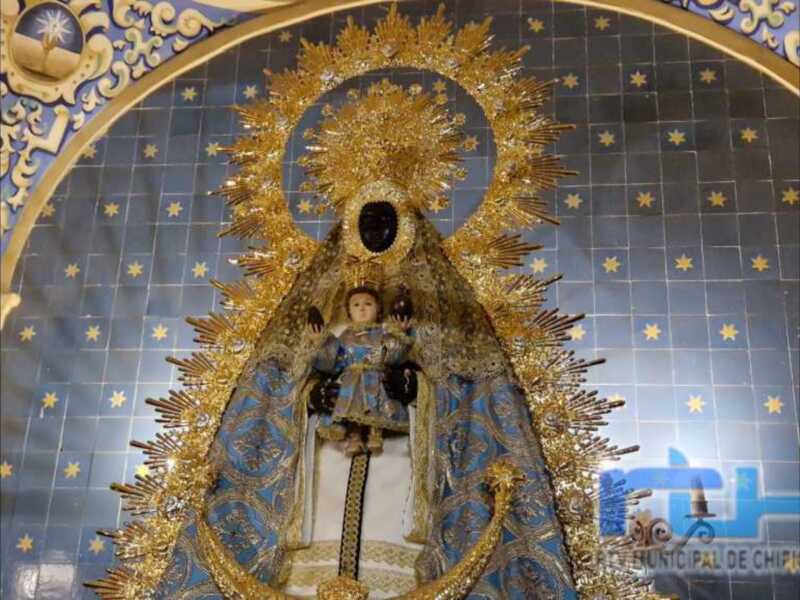 Imagen de la Virgen con el Niño en un entorno decorado con estrellas doradas y azules.