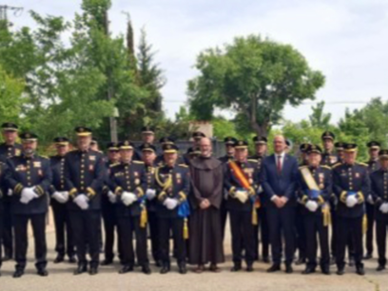 Grande grupo de uniformados y una persona en traje formal en un evento formal al aire libre.