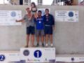 Copa de España de Vela 2023. Podio con medallas y trofeos en el centro. Fondo de muro con carteles informativos sobre la competición.