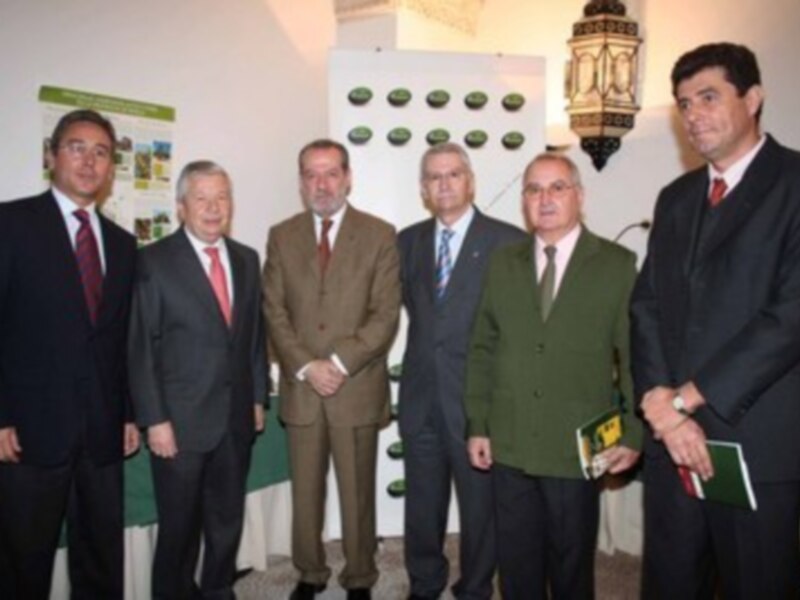 Grupo de hombres en trajes posando para una foto en una reunión formal.