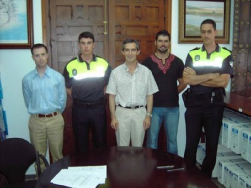 Reunión de trabajo en una oficina, con cinco personas reunidas alrededor de una mesa.
