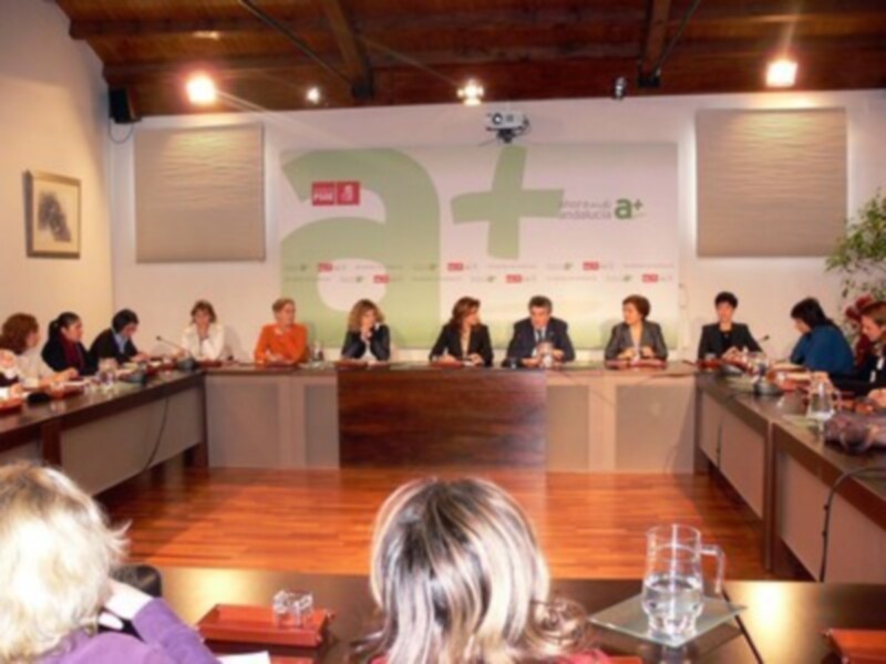 Reunión de trabajo en un ambiente profesional con participantes sentados alrededor de una mesa.