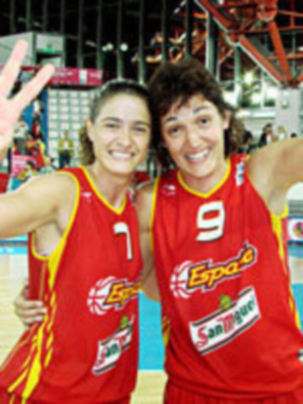 Jugadoras de baloncesto celebrando con camisetas rojas y número 9 en el estadio.