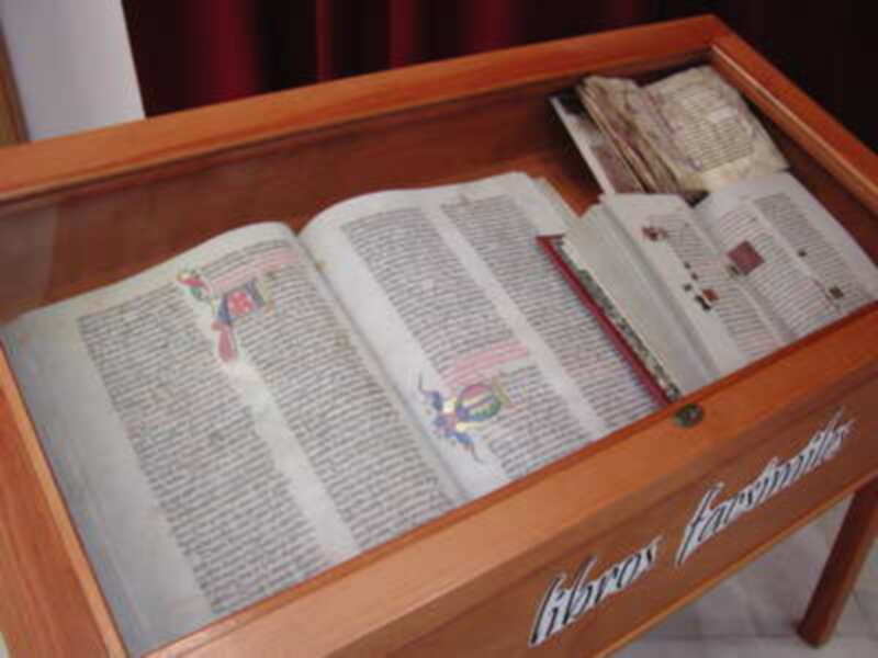 Libros antiguos en un mostrador de madera con detalles decorativos.