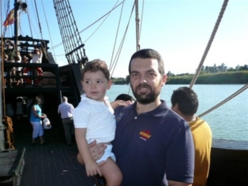 Padre e hijo disfrutan de un viaje en barco tradicional en un día soleado.