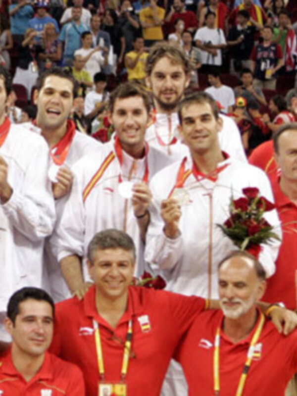 Equipo español celebrando una victoria con medallas y flores en un evento deportivo.