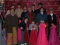 Una familia posa frente a un fondo rojo con el logo de Talbot Rice. Los niños llevan trajes formales y los adultos vestidos con chaquetas.