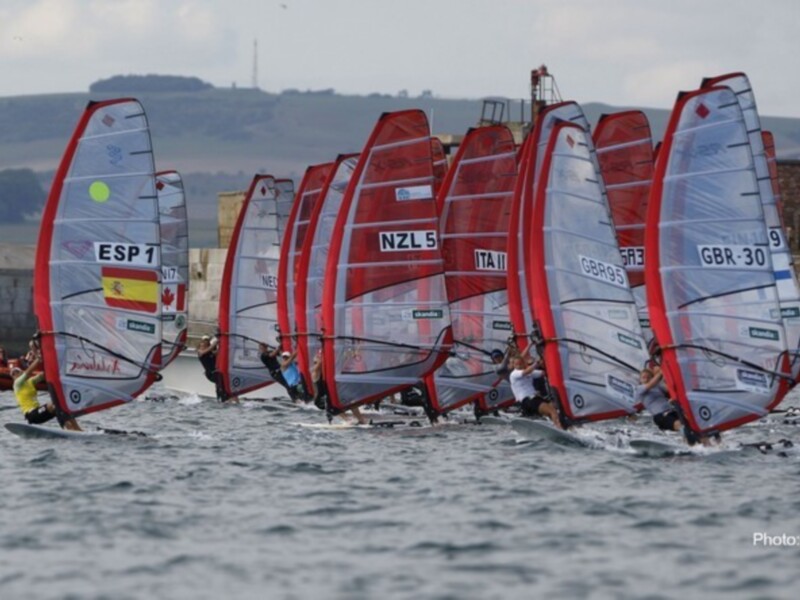Regata de vela en el agua con varios barcos y banderas nacionales.