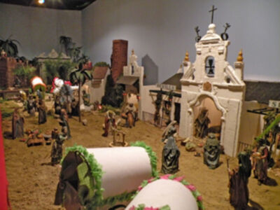 Representación artística de una escena de la Natividad, con figuras y estructuras que recrean un pueblo antiguo.