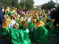 Una multitud vestida de verde y dorado, posiblemente en un desfile o celebración.