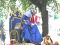 Una figura vestida con un traje tradicional azul y blanco, posiblemente una celebración cultural o religiosa.