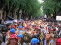 Desfile de músicos en trajes tradicionales, con instrumentos musicales y un cielo nublado.