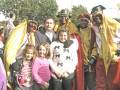 Familia y personajes en trajes festivos posando juntos en un evento al aire libre.