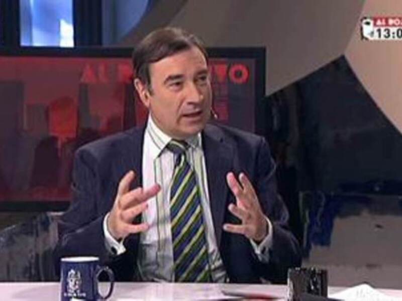 Entrevista en un programa de noticias, hombre en traje hablando con gestos expresivos.
