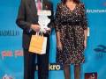 Premios Solidarios en Madrid, con un hombre y una mujer posando frente a un fondo azul con logotipos de patrocinadores.