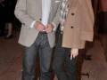 Dos personas vestidas formalmente posando juntos en una calle nocturna.