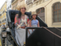 Dos mujeres disfrutan de un viaje en coche de caballos por las calles históricas de Sevilla.
