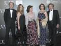 Una familia elegante posa en un evento formal, con dos hombres y tres mujeres vestidas de gala. La imagen muestra una celebración o premiación, con un fondo que incluye logos de organizaciones y empresas.