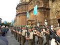 Desfile militar con soldados en uniforme frente a la Catedral de Sevilla.