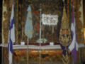 Imagen de un altar con banderas y decoraciones, posiblemente en una iglesia.