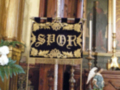 Detalles de una iglesia católica, incluyendo un altar con un letrero que dice 'SPQR' y estatuas religiosas.