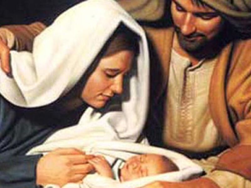 A una mujer y un hombre, posiblemente representando a María y José, con un bebé recién nacido en sus brazos. La escena sugiere una representación de la Navidad o la adoración de los pastores.