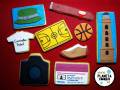Galletas decoradas con temática de deportes, moda y tecnología. Incluyen una camiseta, un baloncesto, una canasta de baloncesto, una cámara y un estuche.