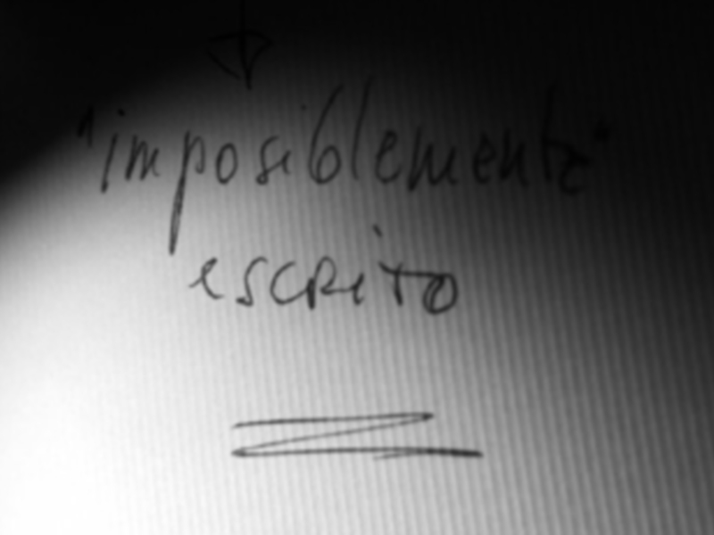 Escritura manuscrita en papel blanco con letras negras. Texto: "imposiblemente escrito".