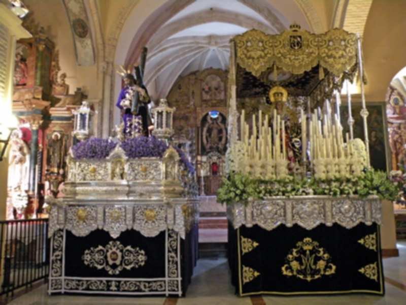 Interior de una iglesia adornada con altares y altares procesionales durante una celebración religiosa.